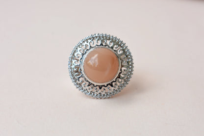 Peach moonstone cabochon ring in 925 silver with ornate scrollwork setting