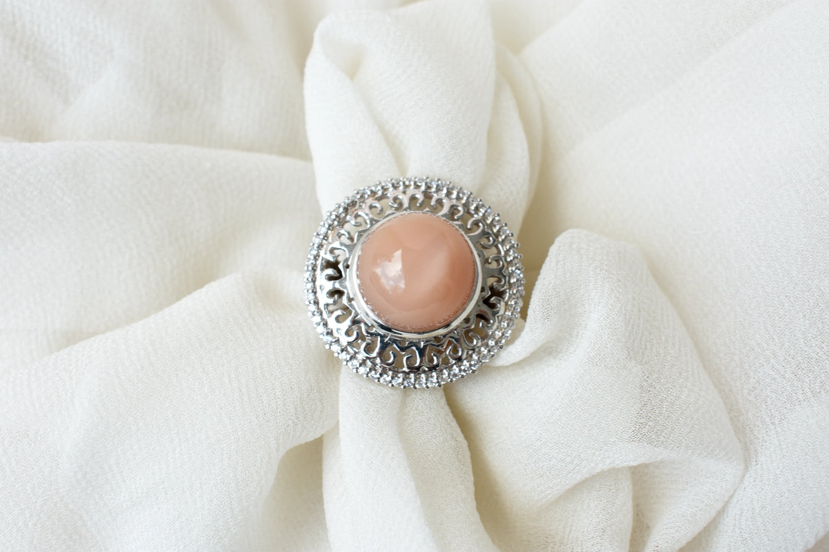 Peach moonstone cabochon ring in 925 silver with ornate scrollwork setting