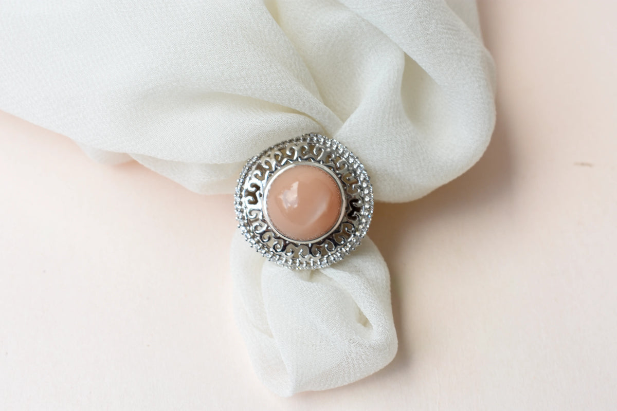 Peach moonstone cabochon ring in 925 silver with ornate scrollwork setting
