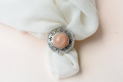 Peach moonstone cabochon ring in 925 silver with ornate scrollwork setting