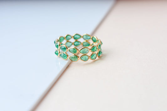 Pear-cut emerald lattice eternity ring in 18K gold with bezel setting