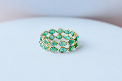 Pear-cut emerald lattice eternity ring in 18K gold with bezel setting