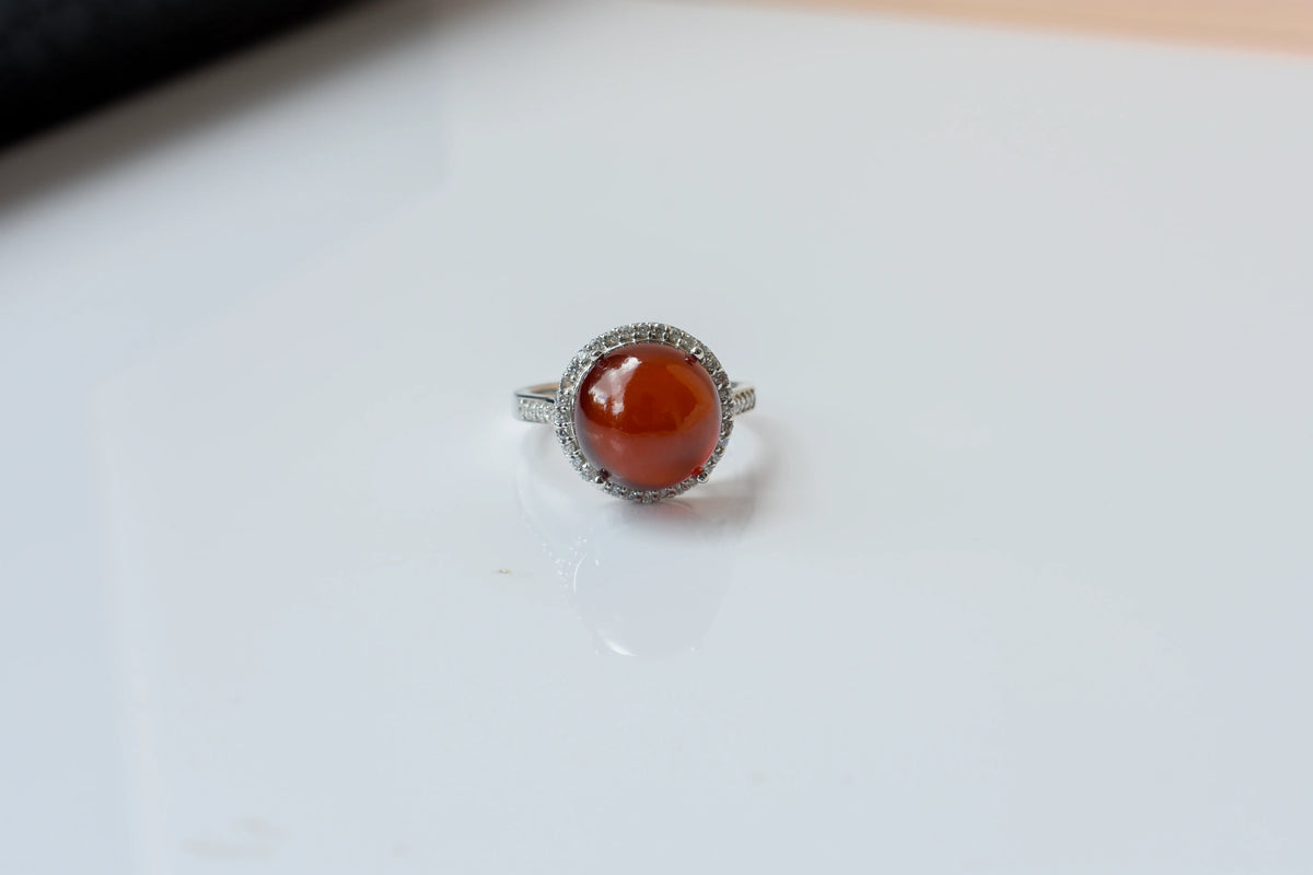 Round orange cabochon ring with pavé halo in 925 silver