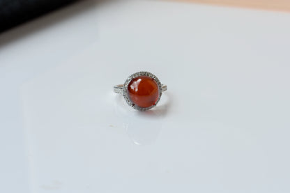 Round orange cabochon ring with pavé halo in 925 silver