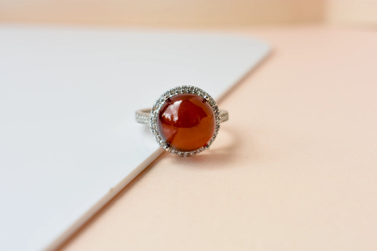Round orange cabochon ring with pavé halo in 925 silver