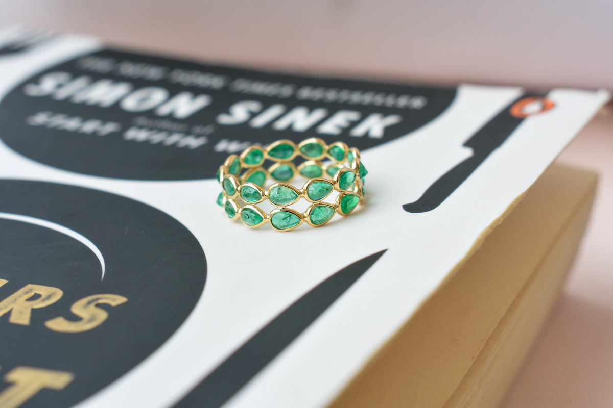 Pear-cut emerald lattice eternity ring in 18K gold with bezel setting