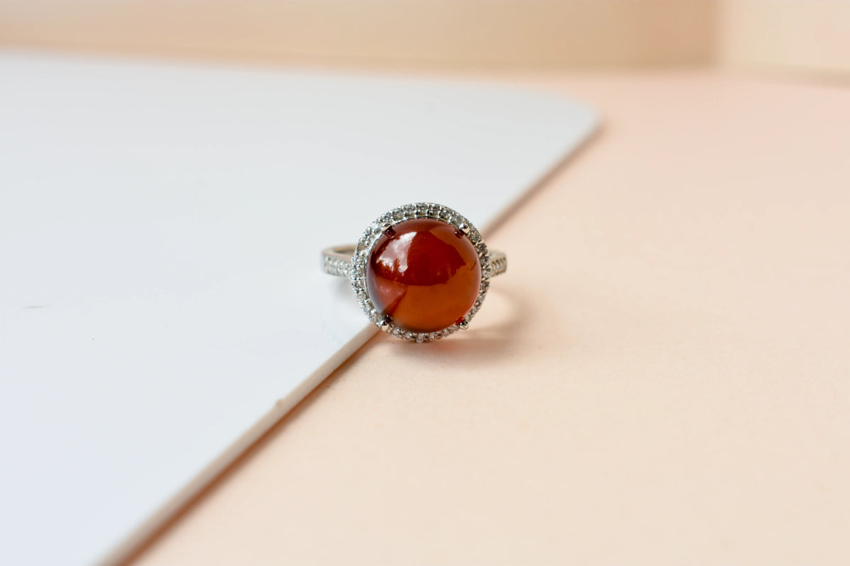 Round orange cabochon ring with pavé halo in 925 silver
