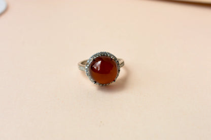 Round orange cabochon ring with pavé halo in 925 silver