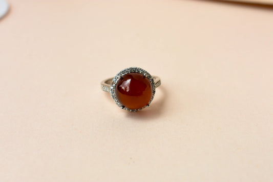 Round orange cabochon ring with pavé halo in 925 silver
