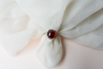 Round orange cabochon ring with pavé halo in 925 silver