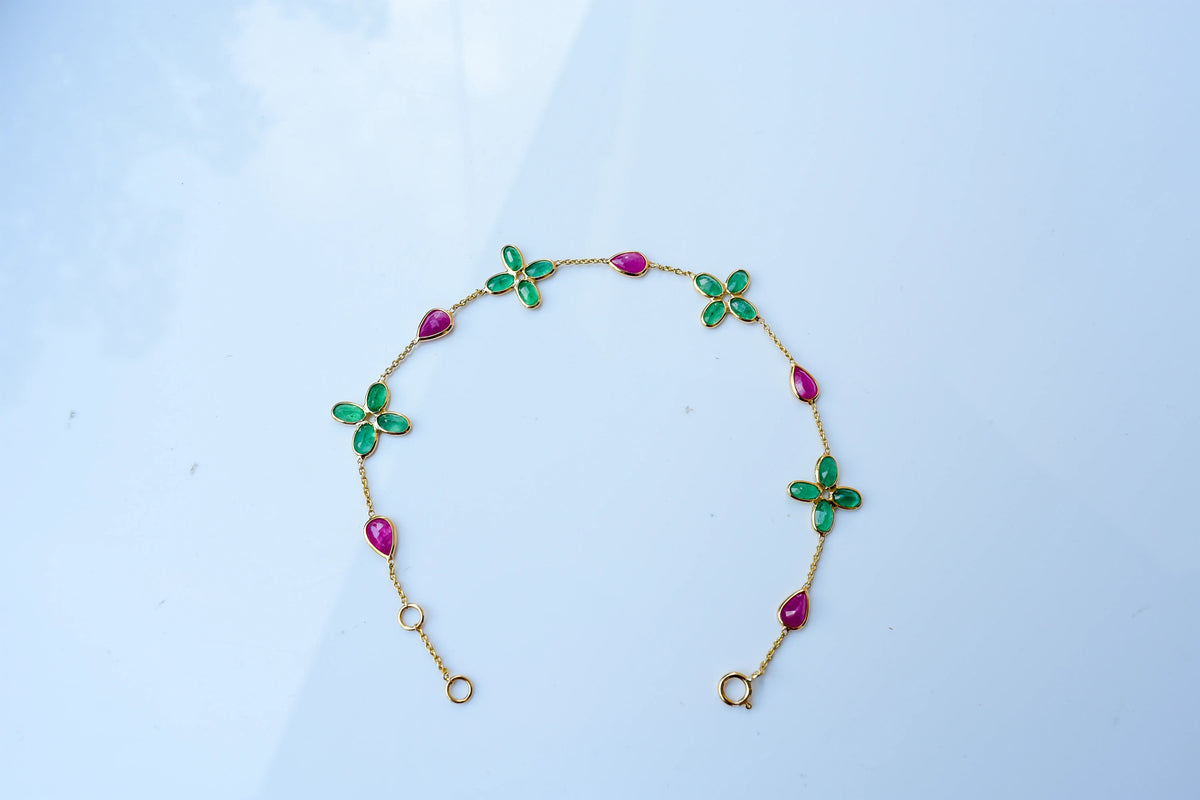 18K gold bracelet with emerald quatrefoil clusters and ruby drops