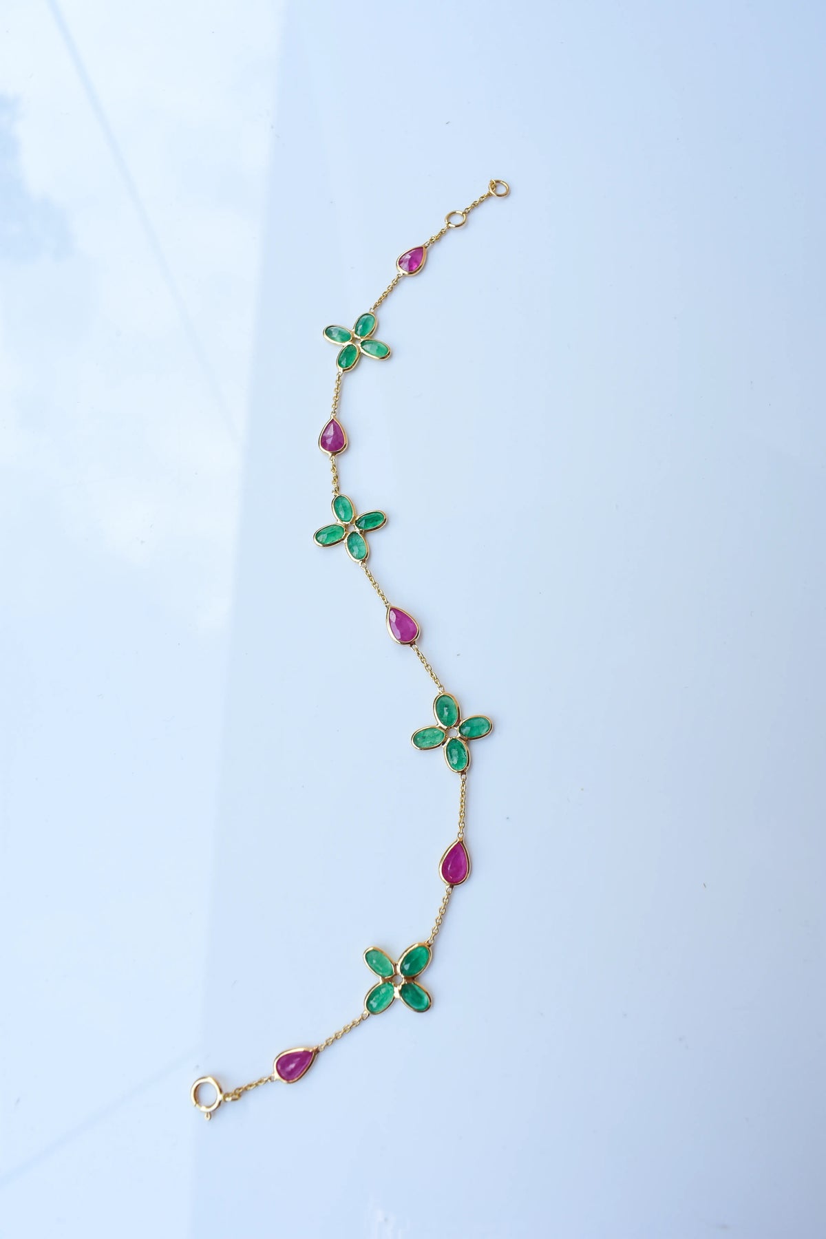 18K gold bracelet with emerald quatrefoil clusters and ruby drops