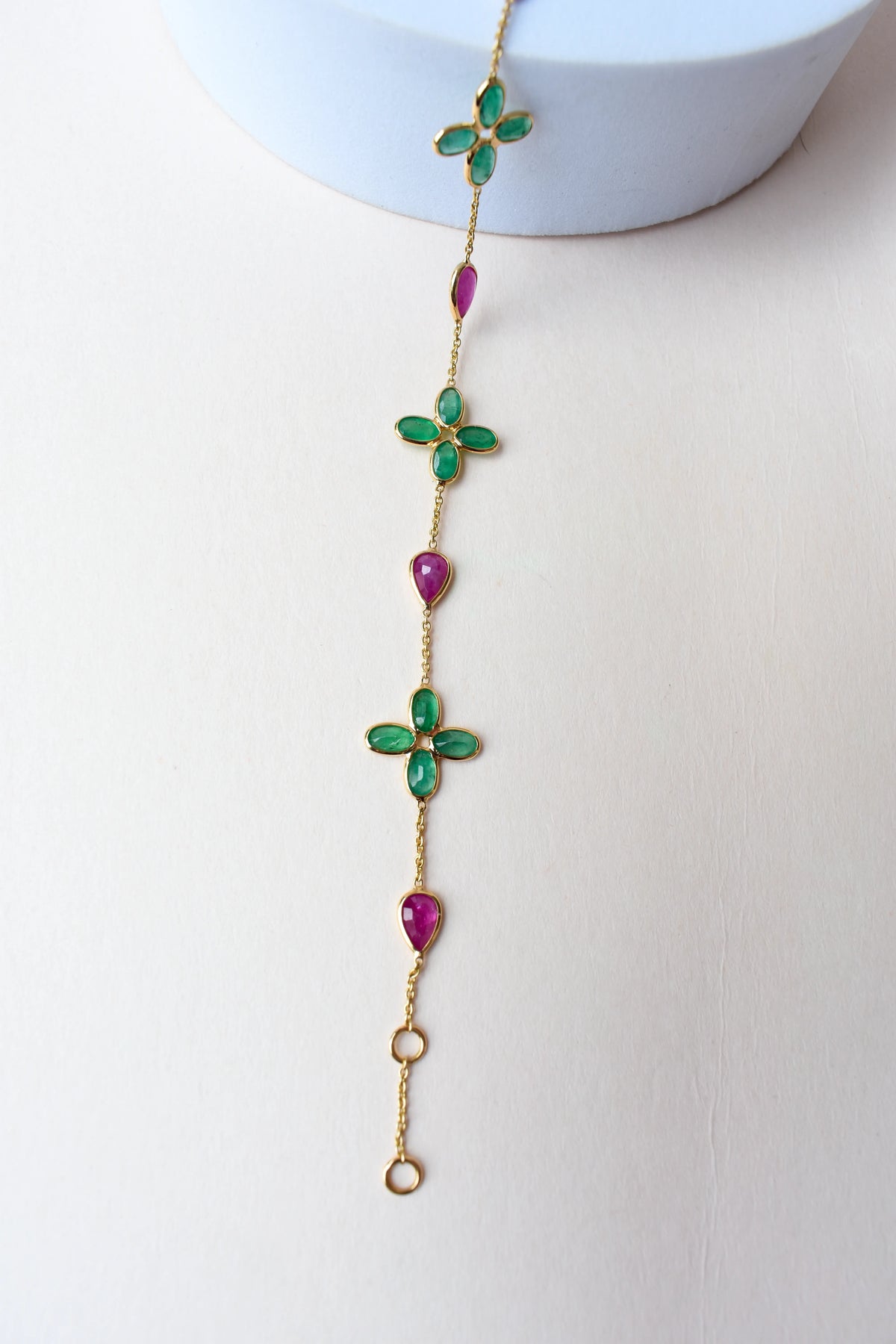18K gold bracelet with emerald quatrefoil clusters and ruby drops