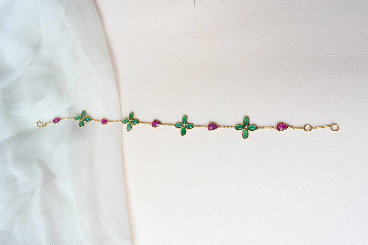 18K gold bracelet with emerald quatrefoil clusters and ruby drops