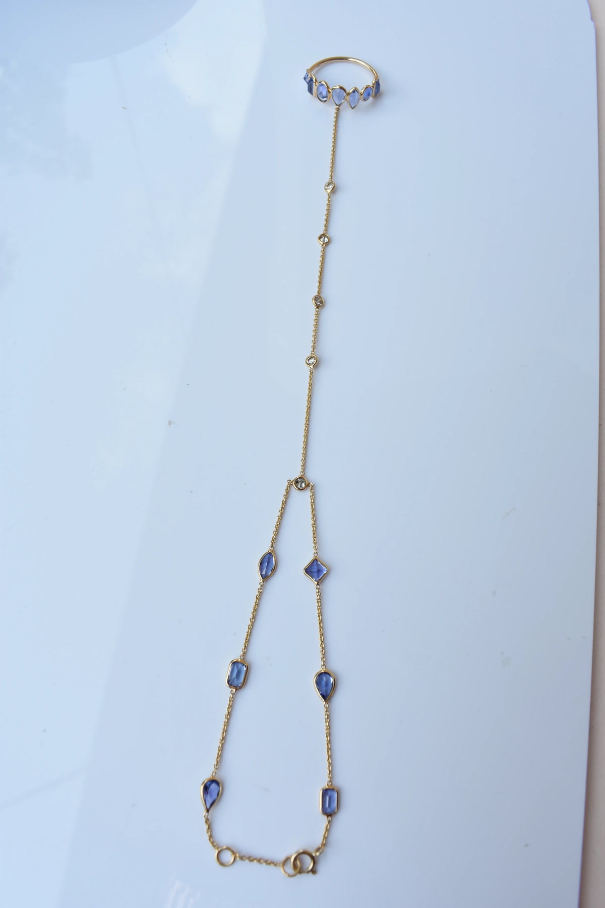 18K gold hand chain with tanzanite ring and diamond wrist accents