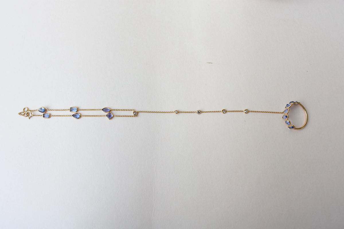 18K gold hand chain with tanzanite ring and diamond wrist accents