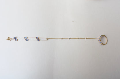 18K gold hand chain with tanzanite ring and diamond wrist accents