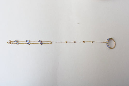 18K gold hand chain with tanzanite ring and diamond wrist accents