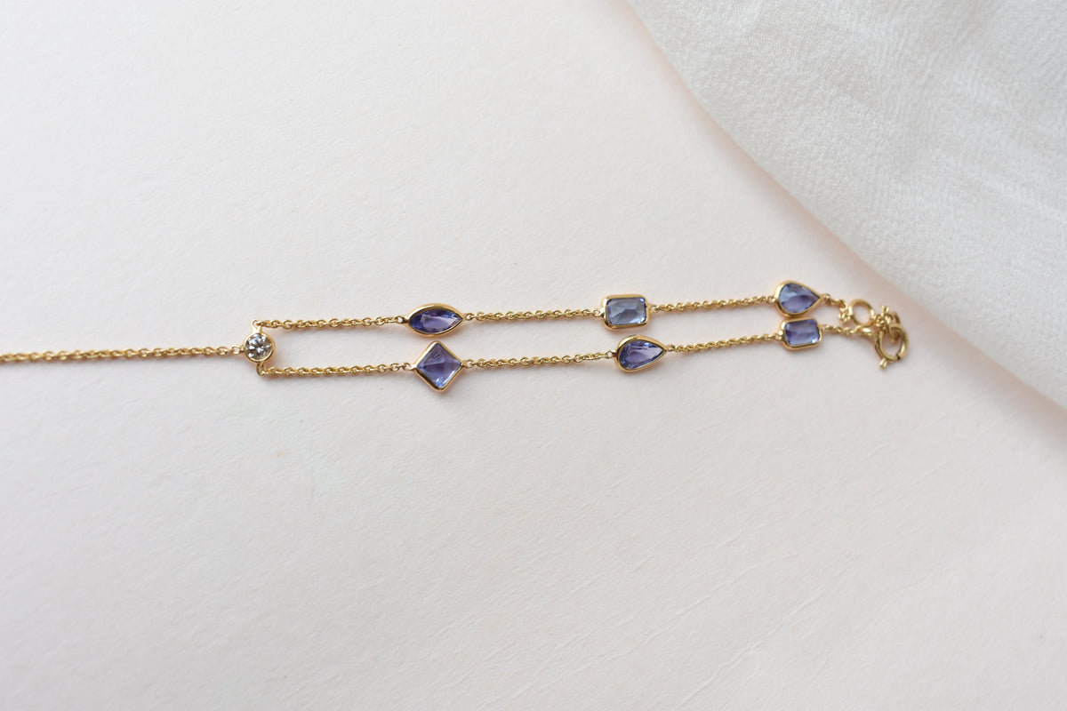 18K gold hand chain with tanzanite ring and diamond wrist accents