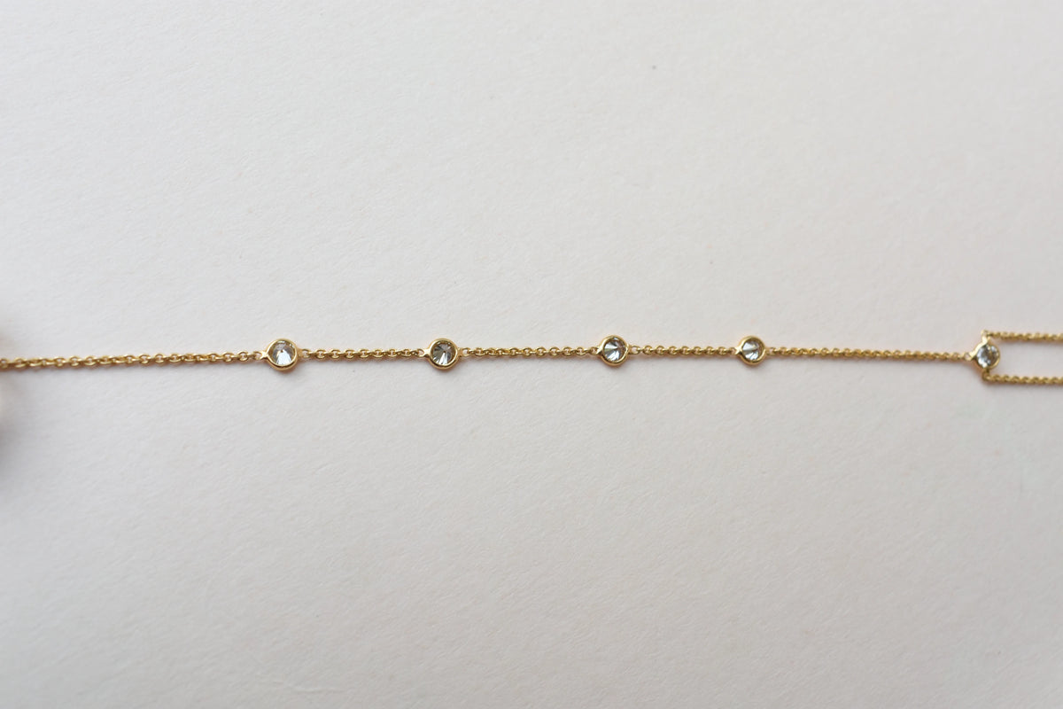 18K gold hand chain with tanzanite ring and diamond wrist accents