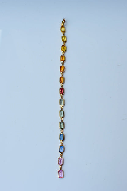18K gold pendant with a graduated line of bezel-set multicolor sapphires
