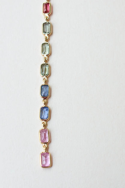 18K gold pendant with a graduated line of bezel-set multicolor sapphires