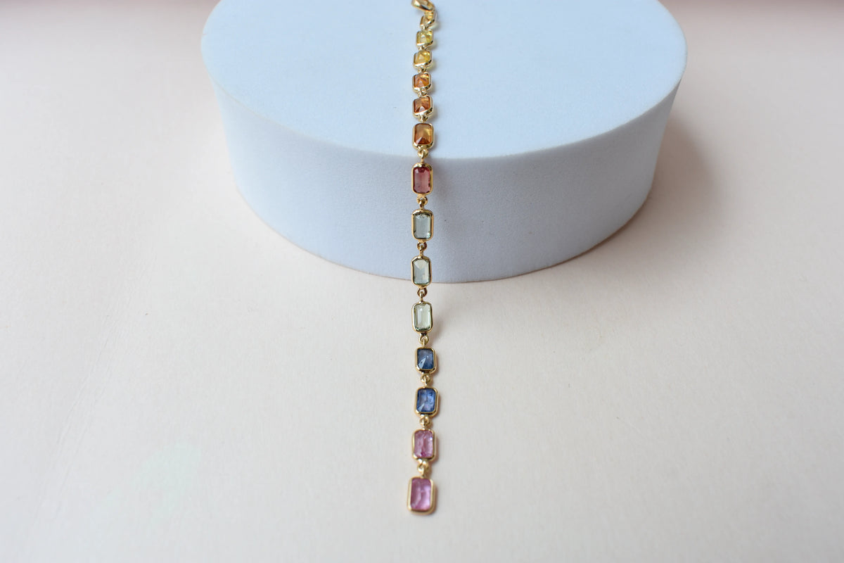 18K gold pendant with a graduated line of bezel-set multicolor sapphires