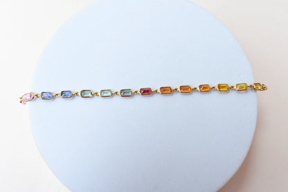 18K gold pendant with a graduated line of bezel-set multicolor sapphires