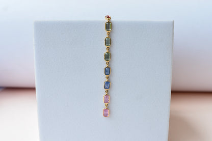 18K gold pendant with a graduated line of bezel-set multicolor sapphires