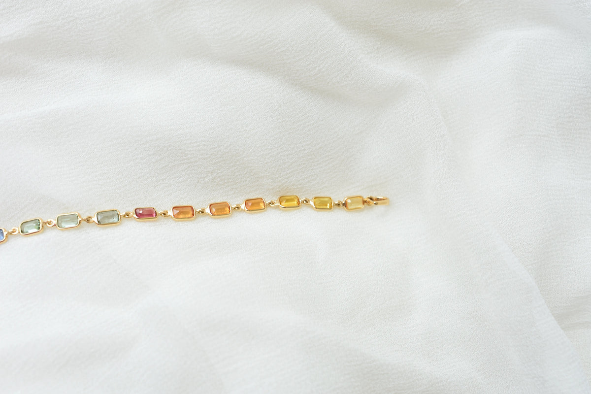 18K gold pendant with a graduated line of bezel-set multicolor sapphires
