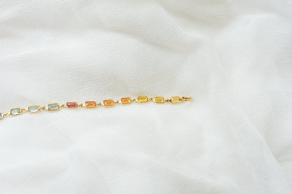 18K gold pendant with a graduated line of bezel-set multicolor sapphires