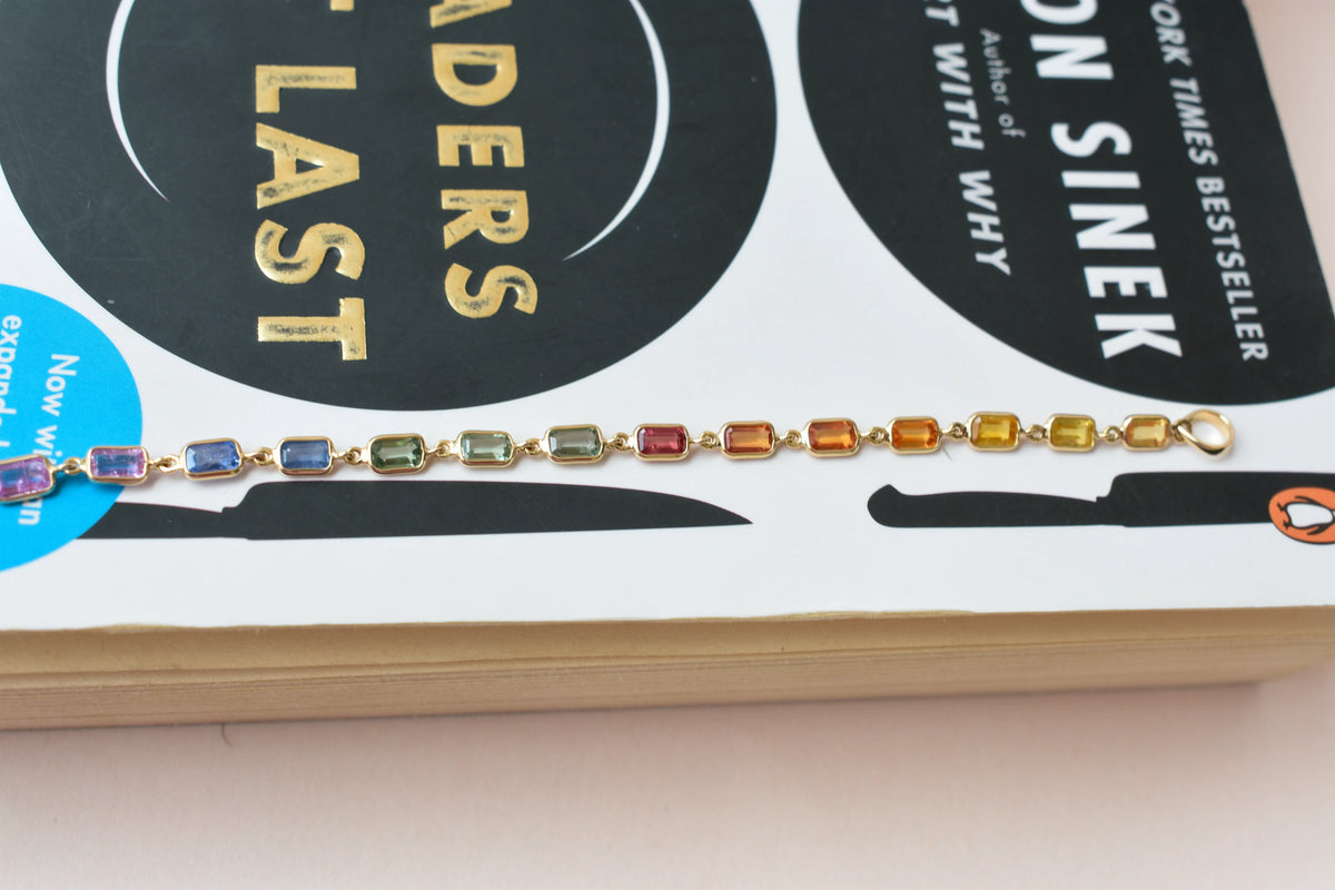 18K gold pendant with a graduated line of bezel-set multicolor sapphires