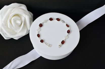 Garnet station bracelet with bezel-set stones and filigree flower links in 925 silver