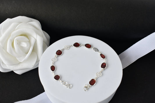 Garnet station bracelet with bezel-set stones and filigree flower links in 925 silver