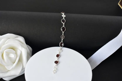 Garnet station bracelet with bezel-set stones and filigree flower links in 925 silver