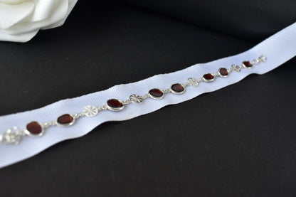 Garnet station bracelet with bezel-set stones and filigree flower links in 925 silver