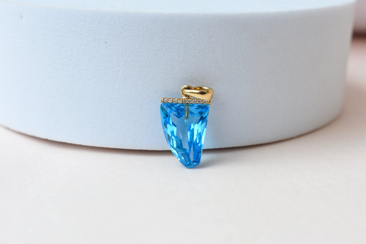 18K gold pendant with faceted blue topaz and diamond bail
