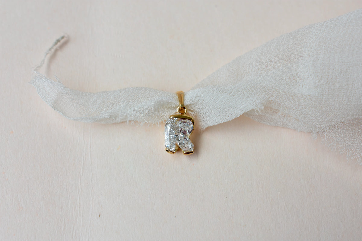 18K gold pendant with lab-grown diamond cut into the letter R
