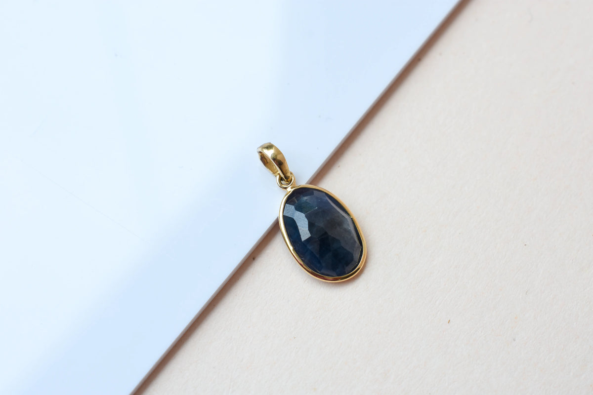 18K gold pendant with bezel-set oval blue sapphire