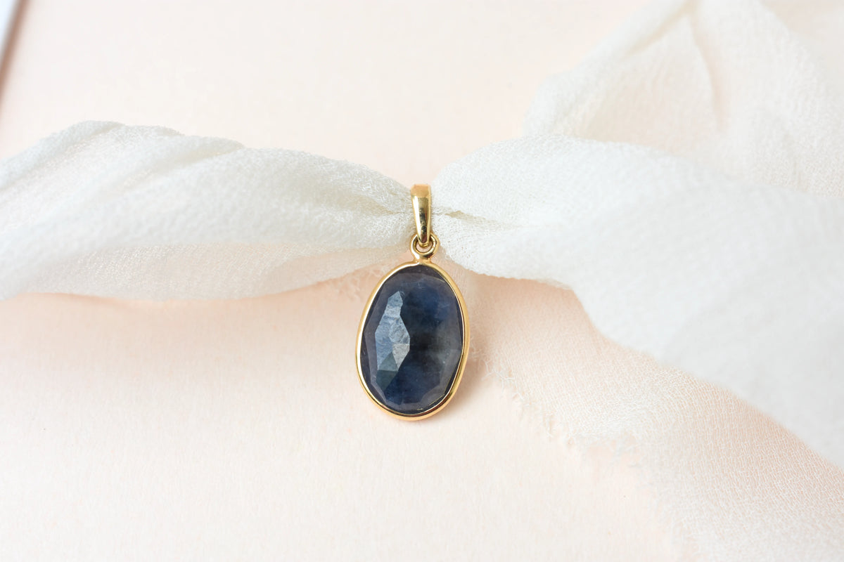 18K gold pendant with bezel-set oval blue sapphire