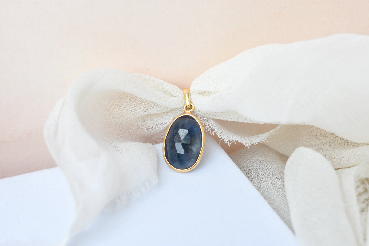 18K gold pendant with bezel-set oval blue sapphire