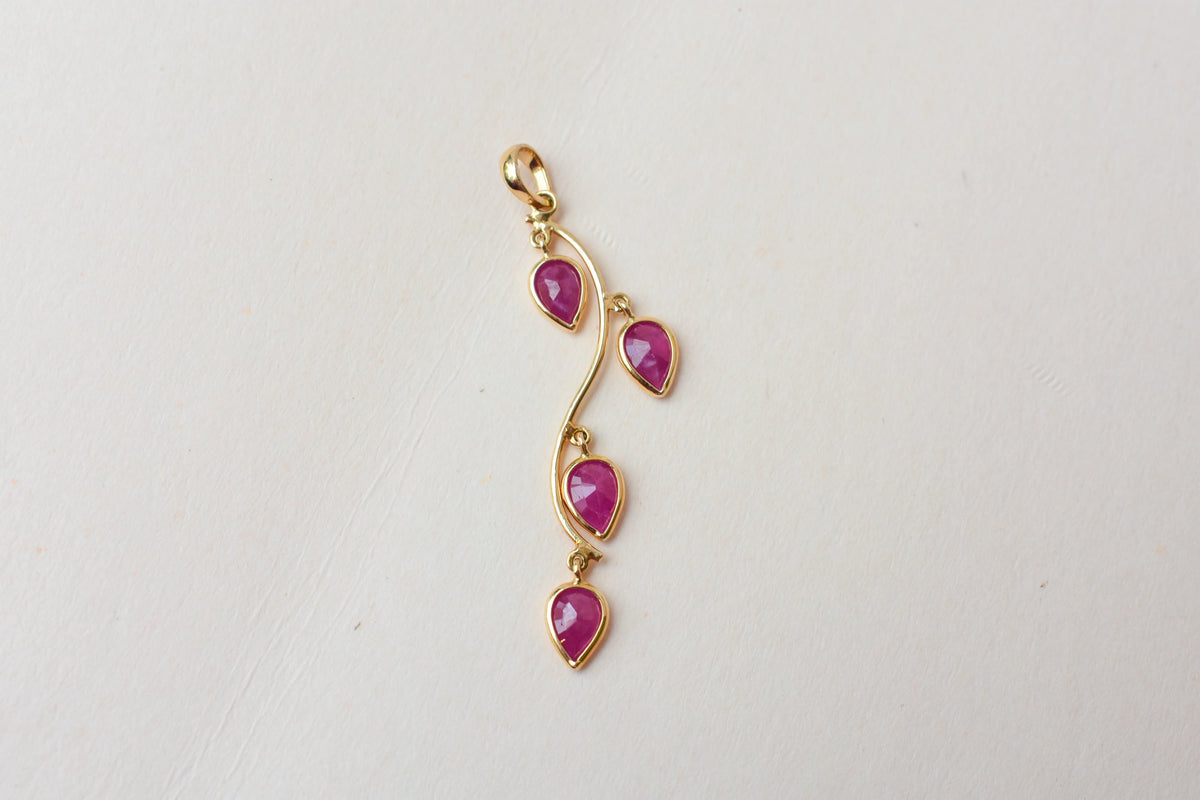 18K gold pendant with four bezel-set pear rubies on a vine design