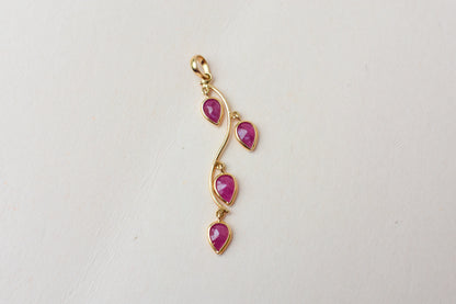 18K gold pendant with four bezel-set pear rubies on a vine design