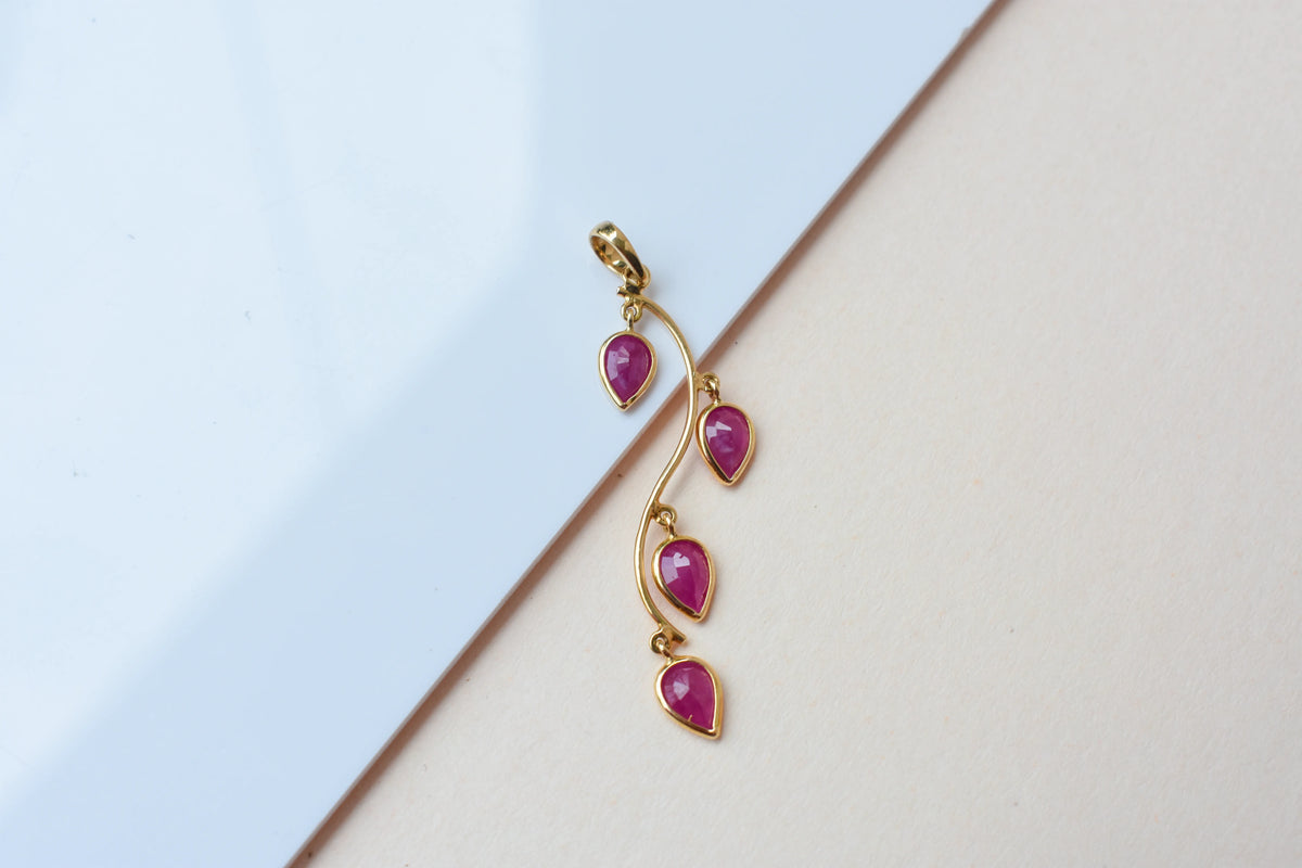 18K gold pendant with four bezel-set pear rubies on a vine design