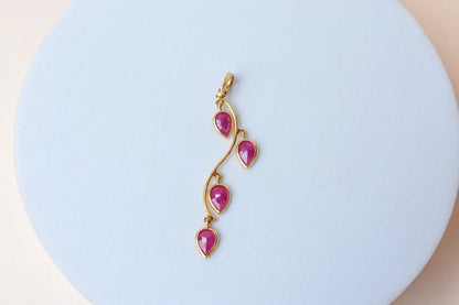 18K gold pendant with four bezel-set pear rubies on a vine design