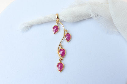 18K gold pendant with four bezel-set pear rubies on a vine design