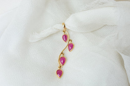 18K gold pendant with four bezel-set pear rubies on a vine design