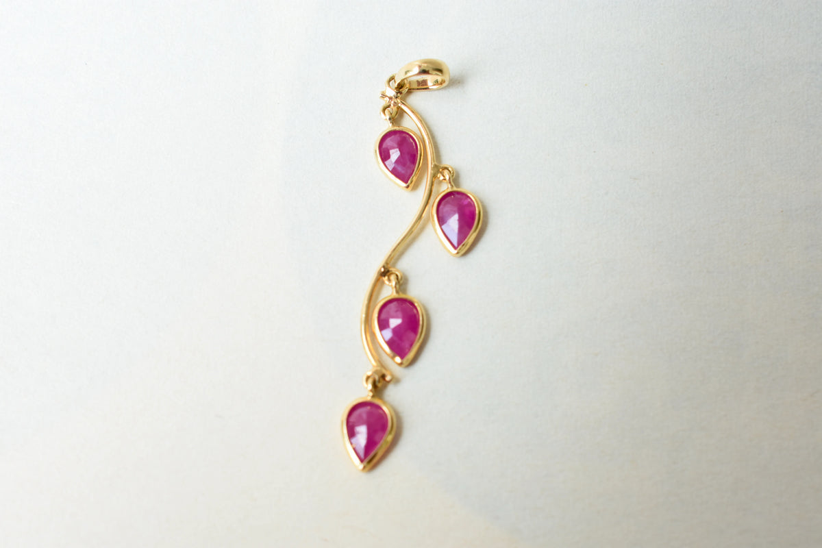 18K gold pendant with four bezel-set pear rubies on a vine design