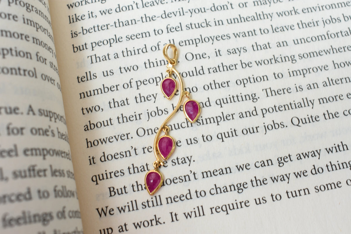 18K gold pendant with four bezel-set pear rubies on a vine design