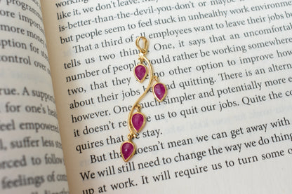 18K gold pendant with four bezel-set pear rubies on a vine design